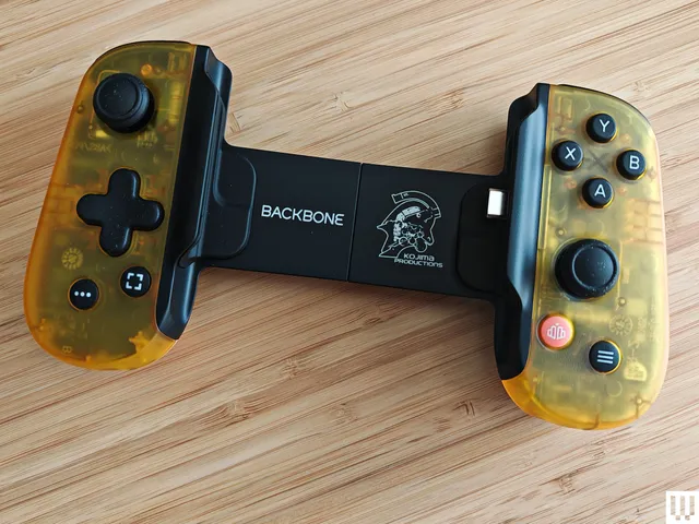 Yellow semi-clear video game controller with long backplate connecting each side. Left side has a joystick and directional pad. Right side has 4 buttons and a joystick.